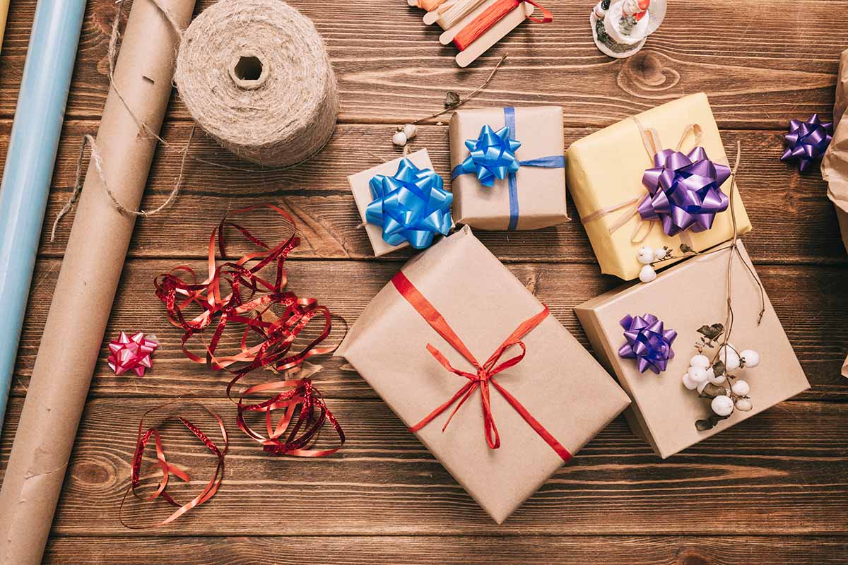 Horizontal image of a stack of presents with bows on a wooden table.