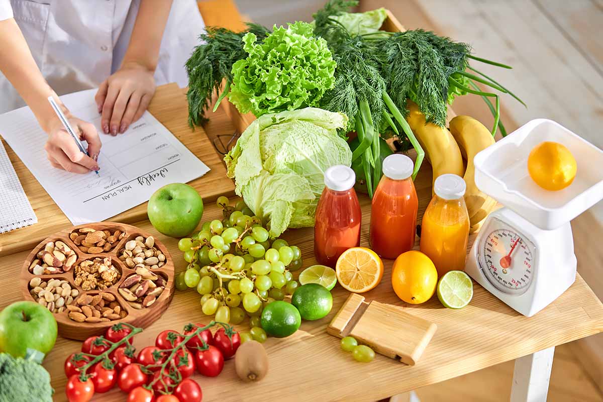 Horizontal image of planning what to eat for the week at a table surrounded by fresh and healthy ingredients.