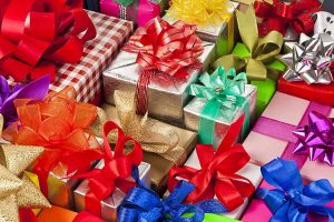 Horizontal image of assorted wrapped presents with ribbons.