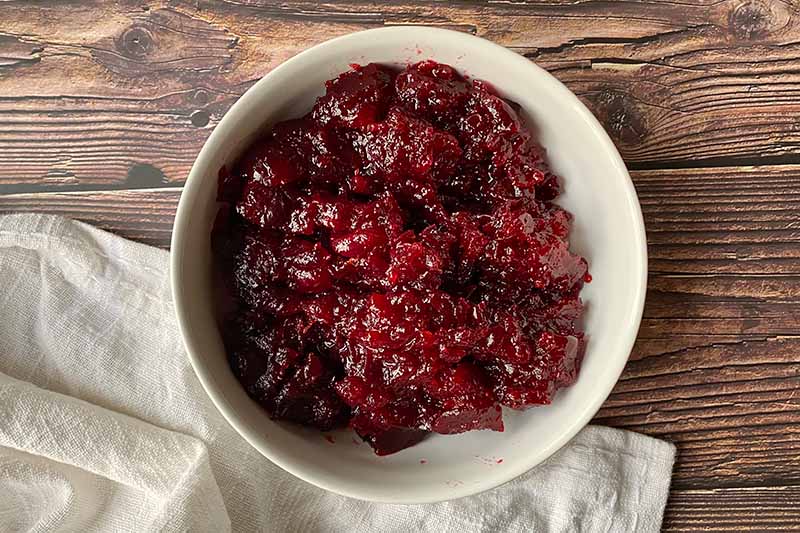 Horizontal image of a thick cranberry sauce in a white bowl.