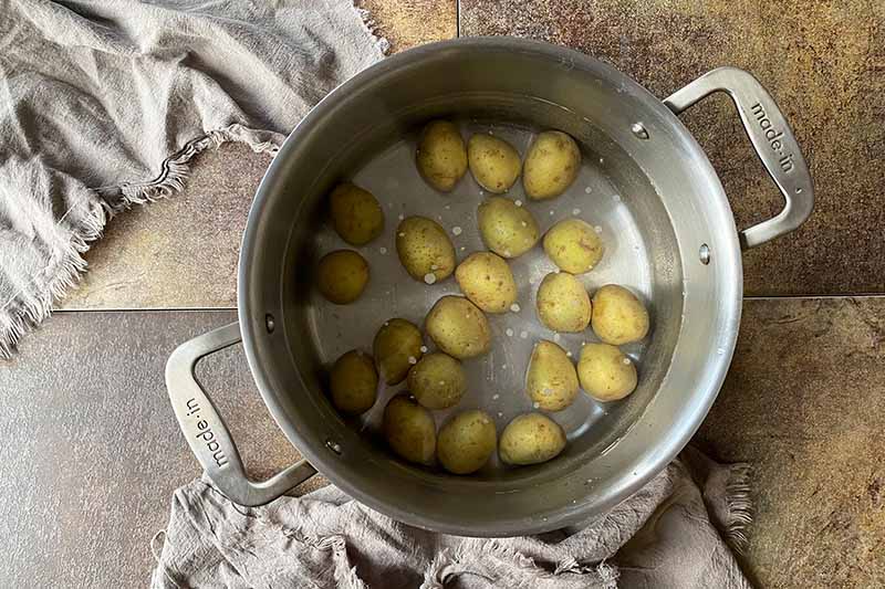 Horizontal image of boiling spuds in a large stockpot.