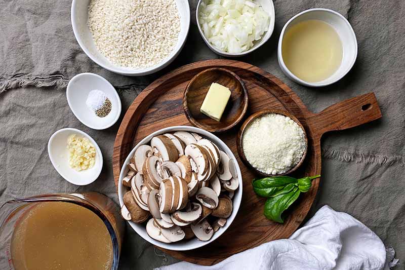 Horizontal image of prepped ingredients in assorted ceramic and wooden bowls.