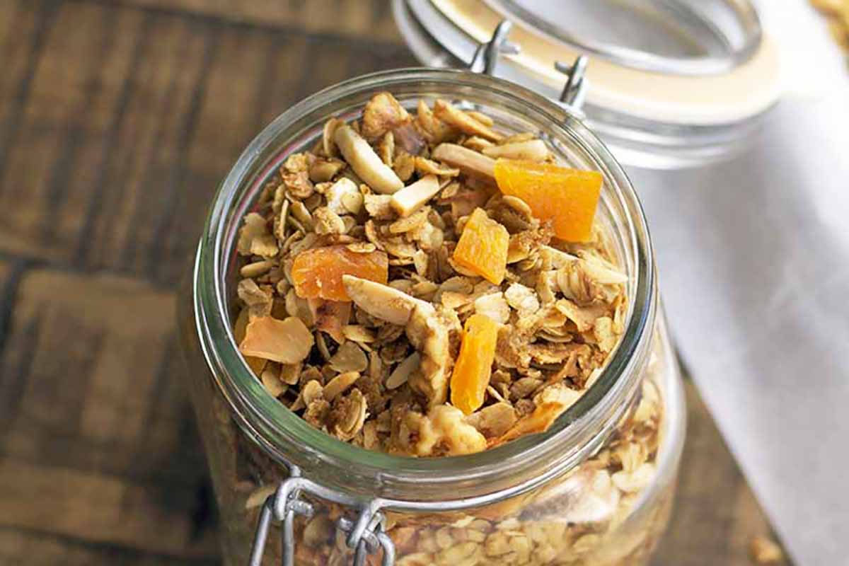 Horizontal image of granola with dried apricots in a jar.