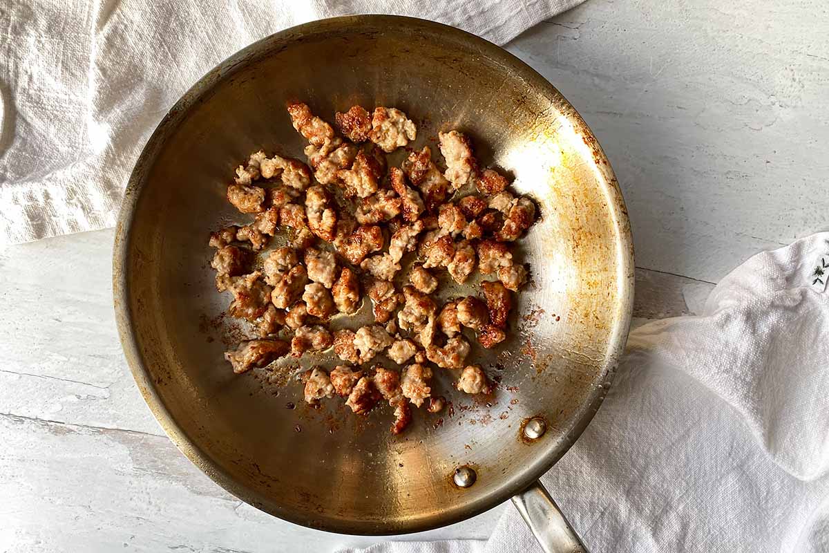 Horizontal image of cooking sausage crumbles in a pan.